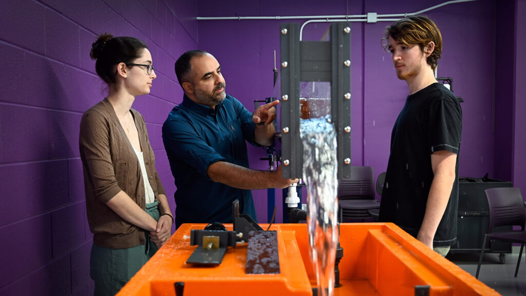 Three researchers collaborate in a colorful lab space.