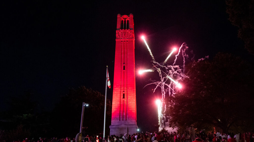 A photo of fireworks at the Belltower, with a peek of crowd at the bottom.