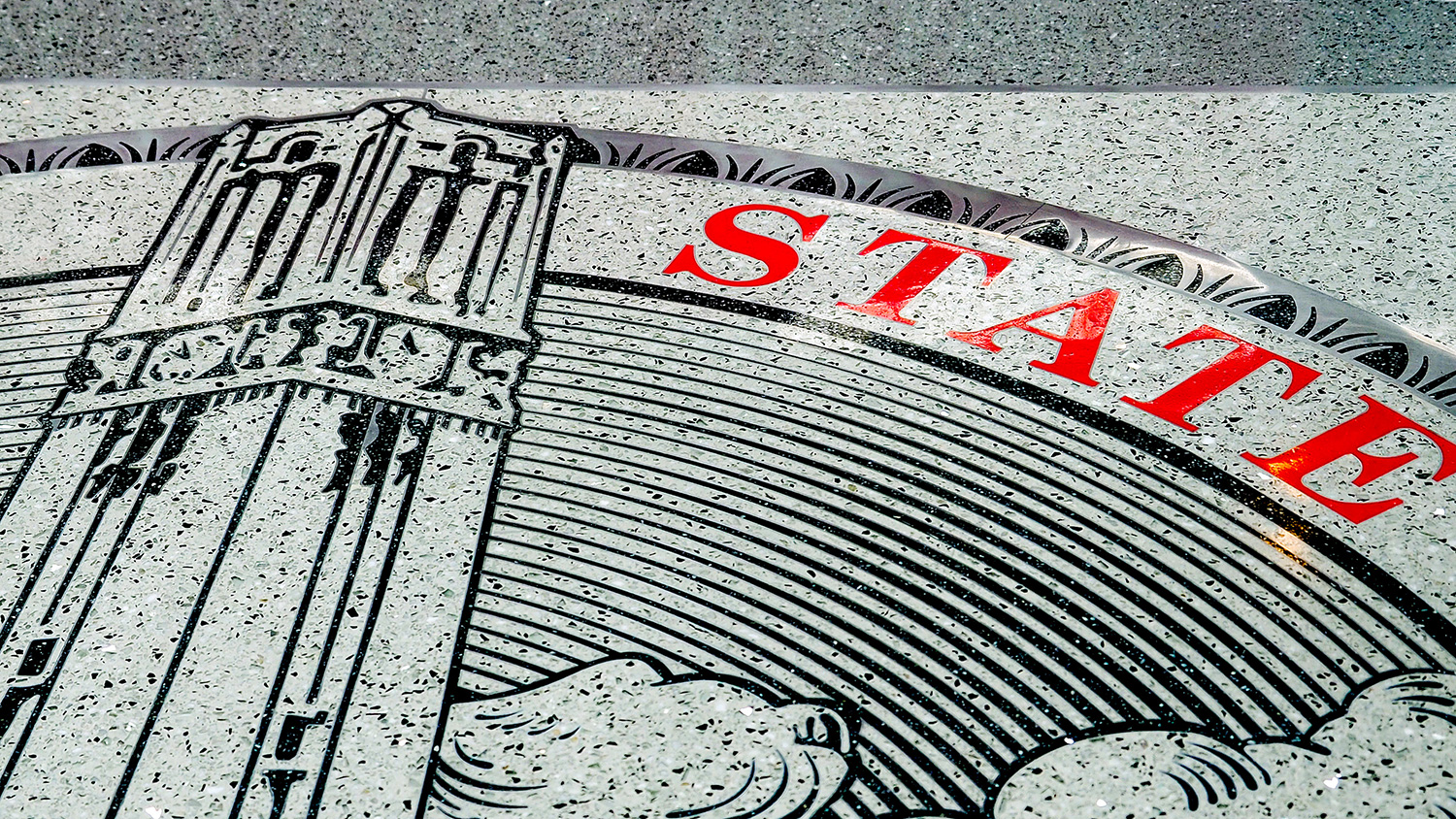 An NC State seal on the floor of Talley Student Union.