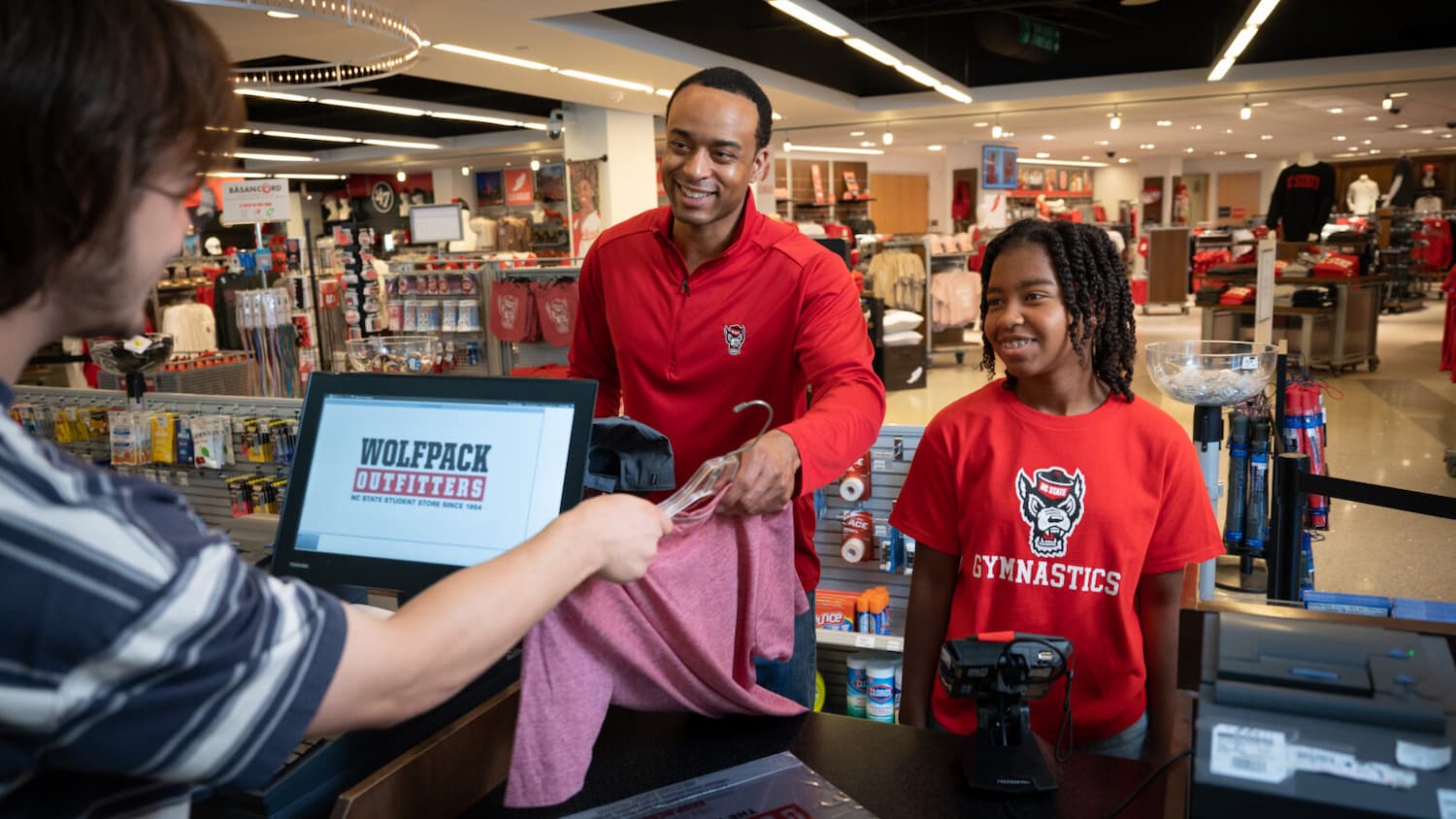 A family purchases licensed NC State merchandise at Wolfpack Outfitters.